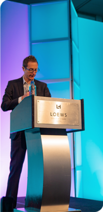 Presenter speaking at a conference podium